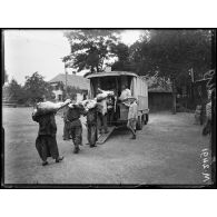 Abattoir militaire de Fellering, transport à dos d'hommes de quartiers de boeufs abattus et mis en autobus. [légende d'origine]