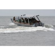 Des soldats congolais naviguent à bord d'une barque en direction de la Pointe Denis au centre d'aguerrissement Outre-Mer et étranger (CAOME) de Libreville, au Gabon.<br>