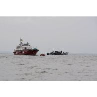 Des soldats congolais naviguent à bord d'une barque en direction de la Pointe Denis, au Gabon.