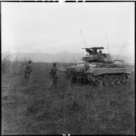 Patrouille de l'infanterie avec l'appui de blindés du 3e régiment de marche du 1er régiment de chasseurs à cheval (RCC) au cours d'une offensive contre des positions de l'Armée populaire vietnamienne à Diên Biên Phu.