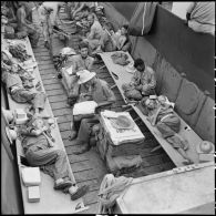 Prisonniers de guerre de l'Union française libérés par l'Armée populaire vietnamienne installés dans la cuve d'un chaland de débarquement au cours de leur rapatriement vers Hanoï.