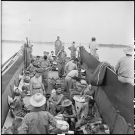 Prisonniers de guerre de l'Union française libérés par l'Armée populaire vietnamienne installés dans la cuve d'un chaland de débarquement au cours de leur rapatriement vers Hanoï.