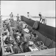 Prisonniers de guerre de l'Union française libérés par l'Armée populaire vietnamienne installés dans la cuve d'un chaland de débarquement au cours de leur rapatriement vers Hanoï.