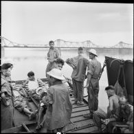 Prisonniers de guerre de l'Union française libérés par l'Armée populaire vietnamienne installés dans la cuve d'un chaland de débarquement au cours de leur rapatriement vers Hanoï.