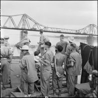 Prisonniers de guerre de l'Union française libérés par l'Armée populaire vietnamienne installés dans la cuve d'un chaland de débarquement au cours de leur rapatriement vers Hanoï.