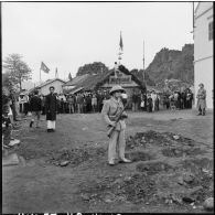 Les habitants de Campha attendent l'arrivée des troupes vietminh dans la ville, sous la garde d'éléments de la populaire vietminh et de la police militaire.