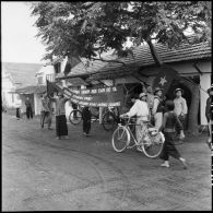 La population assiste à l'entrée des troupes vietminh dans Campha tandis que des partisans installent des banderoles.