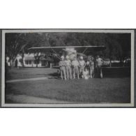 [Un groupe de soldats devant un avion en bois].