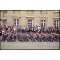 Défilé à pied lors de la cérémonie du 14 juillet 1977 place Joffre devant l'Ecole militaire. Passage d'une unité parachutiste, peut-être le 9e régiment de chasseurs parachutistes (9e RCP), devant la tribune d'officiers étrangers invités.