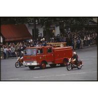 Défilé motorisé lors de la cérémonie du 14 juillet 1979 à la Bastille. Passage des véhicules de la brigade des sapeurs-pompiers de Paris (BSPP) : deux motards sur moto BMW encadrent un camion UNIC 10 75.