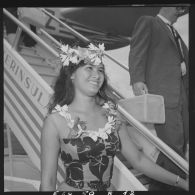 Portrait d'une hôtesse polynésienne en tenue traditionnelle de l'aéroport de Faa'a à Papeete, qui offre des colliers de fleurs aux passagers à leur descente de l'avion.