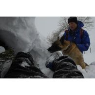 Un maître-chien du PGHM (peloton de gendarmerie de haute montagne) et son chien découvrent une victime sous la neige, lors d'un exercice de recherche après avalanche à Pierrefitte-Nestalas (Hautes-Pyrénées).