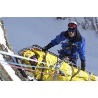 Exercice de secours avec le PGHM (peloton de gendarmerie de haute montagne) sur le (Hautes-Pyrénées) : des secouristes remontent un blessé  avec une civière le long de la paroi.