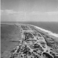 Vue aérienne de la zone technique et de la zone portuaire de Moruroa, avec la rade et la force Alfa au mouillage.