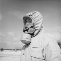 Portrait d'un mécanicien, membre de l'équipe de décontamination des avions Vautour, en tenue de protection, sur l'atoll d'Hao.