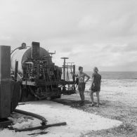 Personnels au pied d'un camion-citerne du service des essences des armées (SEA) sur la base de Hao.