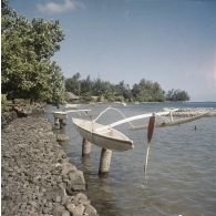 Pirogues de pêche tahitiennes, équipées d'un balancier, installées sur des poteaux.