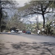 Automobiles et deux-roues circulant dans une rue de Papeete (cours de l'Union sacrée), à proximité d'une station service.