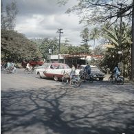 Automobiles et deux-roues circulant dans une rue de Papeete (cours de l'Union sacrée), à proximité d'une station service.