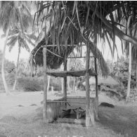 Dans un marae, plateforme souvent construite en pierres volcaniques où se déroulaient les anciens cultes polynésiens, des petites pirogues sont installées sous une construction en bois, à Tahiti.