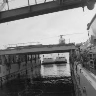 Deux barges transportant des shelters se présentent à l'entrée du radier du transport de chalands de débarquement (TCD) Ouragan dans le lagon de l'atoll de Moruroa.