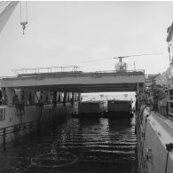 Deux barges transportant des shelters se présentent à l'entrée du radier du transport de chalands de débarquement (TCD) Ouragan dans le lagon de l'atoll de Moruroa.