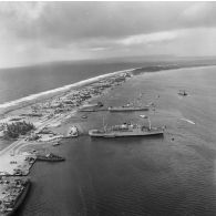 Vue aérienne de la zone aéroportuaire de l'atoll de Moruroa. A quai, les bâtiments-bases (BB) Maurienne (A637) et Médoc (A612), le bâtiment de soutien santé (BSS) Rance (A618).