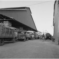 Hangar de stockage de marchandises et flotte de camions de livraison au port de Papeete.