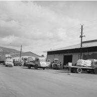 Camions au chargement de marchandises devant un hangar du port de Papeete.