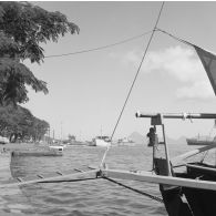 Groupe de garçons près des voiliers au port de plaisance de Papeete. En arrière-plan, l'île de Moorea.