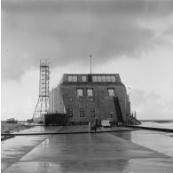 Le site du poste d'enregistrement avancé (PEA) Denise [ou Dindon ?], le bunker, l'antenne de transmission et le chenal, sur l'atoll de Moruroa.