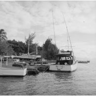 Canots à quai et voiliers en cale sèche au port de plaisance de Papeete. En arrière-plan, l'île de Moorea.