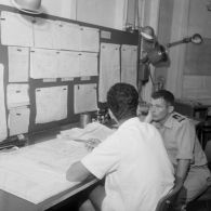 Service météorologique à bord du croiseur De Grasse (C610) : examen de cartes avec un lieutenant de vaisseau.