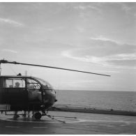 Décontamination d'hélicoptère Alouette III à bord du transport de chalands de débarquement (TCD) Ouragan. Le nuage au fond est le nuage radioactif.