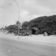 Installations du Centre d’expérimentations du Pacifique (CEP) sur l'atoll d'Hao. Des ouvriers et des légionnaires descendent d'un camion et se dirigent vers une tente en zone de vie.