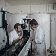 Portrait de deux personnels au laboratoire de développement des films couleur du centre technique (CT) de Mahina (Tahiti).