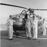 Arrivée du général Charles De Gaulle, président de la République, en hélicoptère Alouette III à bord du croiseur de commandement De Grasse, avec le vice-amiral Jean Lorain, commandant du groupe opérationnel des expérimentations nucléaires (GOEN) et Jean Viard, directeur des essais.