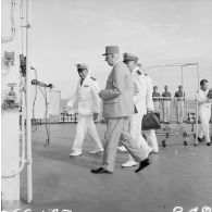 Le général Charles De Gaulle, président de la République, aux côtés du capitaine de vaisseau Michel Teisserenc, commandant du croiseur De Grasse, et du vice-amiral Jean Lorain, commandant du groupe opérationnel des expérimentations nucléaires (GOEN).