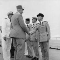 Le général Charles De Gaulle, président de la République, salue des capitaines aux côtés du capitaine de vaisseau Michel Teisserenc, commandant du croiseur De Grasse.