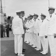 Le général Charles De Gaulle, président de la République, salue des officiers supérieurs de marine aux côtés du capitaine de vaisseau Michel Teisserenc, commandant du croiseur De Grasse.