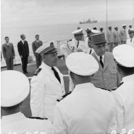 Le général Charles De Gaulle, président de la République, salue des officiers subalternes de marine aux côtés du capitaine de vaisseau Michel Teisserenc, commandant du croiseur De Grasse.