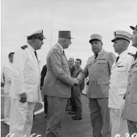 Le général Charles De Gaulle, président de la République, salue le général de brigade Maurice André, chef du service mixte de sécurité radiologique (SMSR), aux côtés du vice-amiral Jean Lorain, commandant du groupe opérationnel des expérimentations nucléaires (GOEN), à bord du croiseur De Grasse.