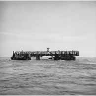 Elément flottant du pont de la Taunoa avec des militaires du 5e régiment mixte du Pacifique (5e RMP), zone portuaire de Fare ute à Papeete, 1964.