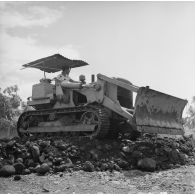 Ouvrier tahitien travaillant au terrassement avec un tractopelle civil, camp d'Arue (?), vers 1963-1964.