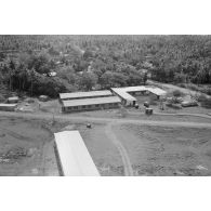 Vue aérienne du site. Locaux neufs. Camions-ambulances devant le centre médical d'Arue (?). Entrée du Centre d'expérimentations du Pacifique (CEP). Fin de la construction du camp d'Arue.