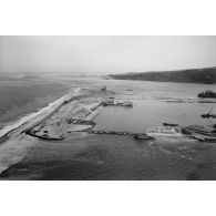 Vue aérienne du site portuaire de Papeete. Pétrolier Verdon (A634) à quai. Construction d'un pont flottant. Drague suceuse New Jersey de la société Stanco. Aéroport de Faa'a. [vue inversée]