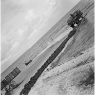 Camion-citerne et containers sur la jetée. Chaînes. Peut-être sur l'atoll d'Hao.