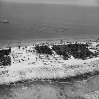 Vue aérienne de l'aviso-colonial Francis Garnier F730 et autres embarcations au mouillage. Peut-être sur l'atoll de Moruroa.