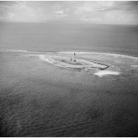 Vue aérienne d'installations sur l'atoll. Phare ou balise. Peut-être l'atoll de Moruroa.