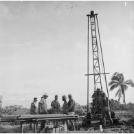 Visite d'une autorité sur un chantier. Engin de forage. Peut-être sur l'atoll de Moruroa.